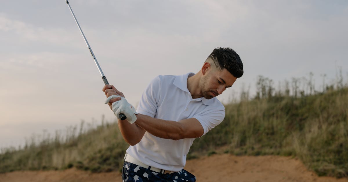 A male golfer taking a swing on a picturesque golf course